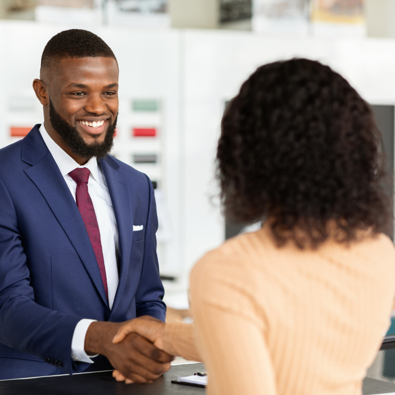 Smiling Car Seller Shaking Hands With Female Customer After Successful Deal, Unrecognizable African American Woman Buying New Vehicle In Dealership Center, Purchasing Automobile In Modern Showroom
